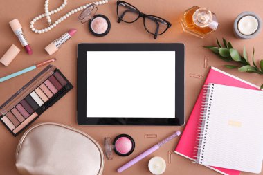 Renkli arka plan görünümlü kozmetik ve modern tablet. Güzellik günlüğü konsepti.