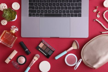 Renkli arka plan görünümlü makyaj malzemeleri ve modern laptop. Güzellik Günlüğü Konsepti
