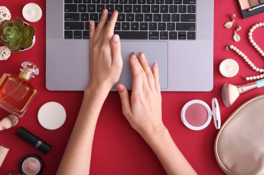 Güzellik blogu konsepti. Modern dizüstü bilgisayar ve kadın elleri, kozmetik üst görünümü yuvalama arka planında. Bağımsız, blog, internet, gönderi.