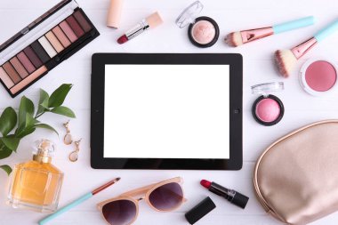 Renkli arka plan görünümlü kozmetik ve modern tablet. Güzellik günlüğü konsepti.