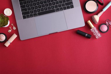 Renkli arka plan görünümlü makyaj malzemeleri ve modern laptop. Güzellik Günlüğü Konsepti