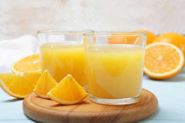 Bardakta portakal suyu, masada portakal ve portakal dilimleri..