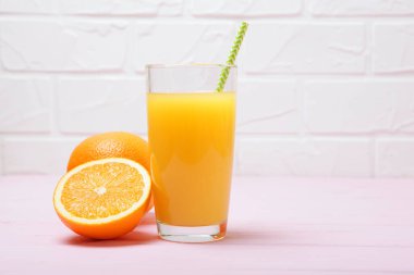 Bardakta portakal suyu, masada portakal ve portakal dilimleri..