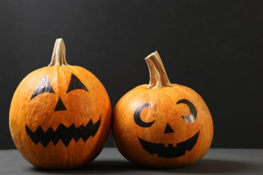 Cadılar Bayramı için renkli arkaplanda boyalı yüzleri olan balkabakları.