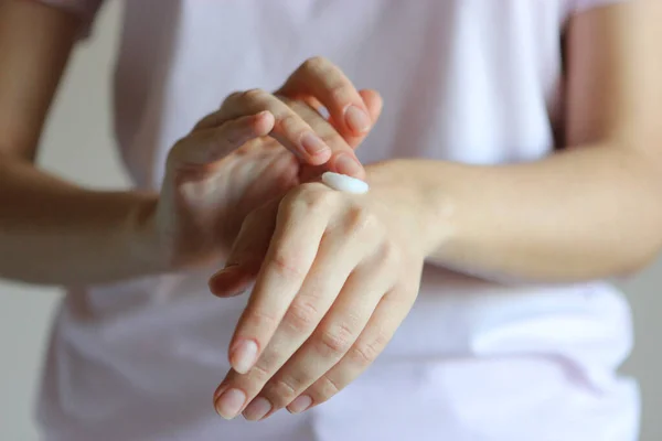 girl uses hand cream. Skin care, skin hydration.