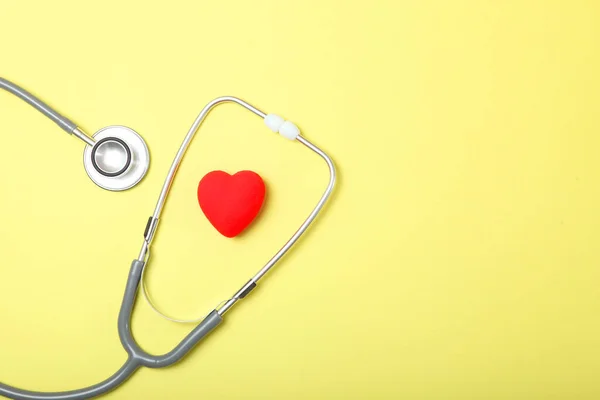 色の背景に聴診器と心臓 — ストック写真