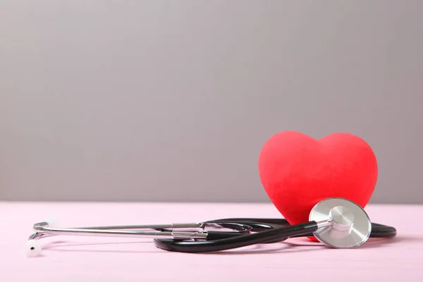 色の背景に聴診器と心臓 — ストック写真