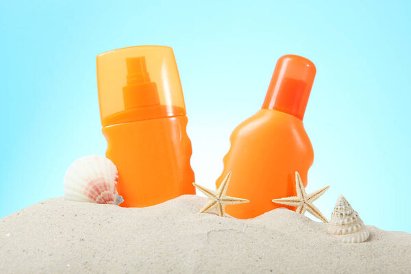 sand, shells, starfish and sunscreen on a blue background. Skin protection from the sun.