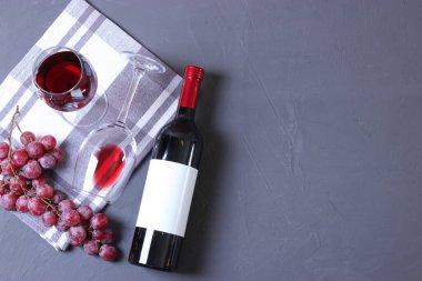 Masanın üstünde kırmızı şarap ve üzüm var..