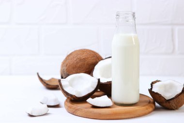 Süt ve kırık hindistan cevizleri masada. Sebze sütü, sebze içeceği..