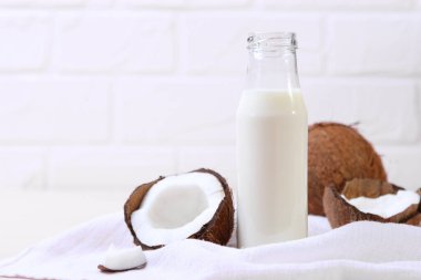 Süt ve kırık hindistan cevizleri masada. Sebze sütü, sebze içeceği..