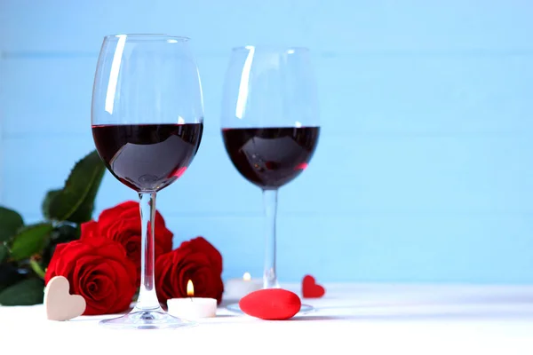 red wine and roses on the table. Valentine\'s day background. A gala dinner for two.