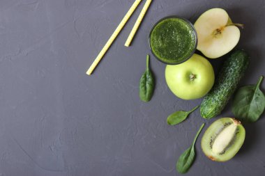 Arınma organizması için yeşil meyve püresi ve taze sebzeler masada.