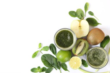 Arınma organizması için yeşil meyve püresi ve taze sebzeler masada.