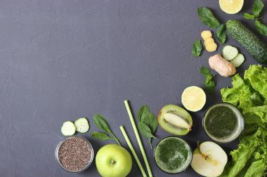 Arınma organizması için yeşil meyve püresi ve taze sebzeler masada.