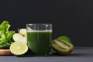 Arınma organizması için yeşil meyve püresi ve taze sebzeler masada.