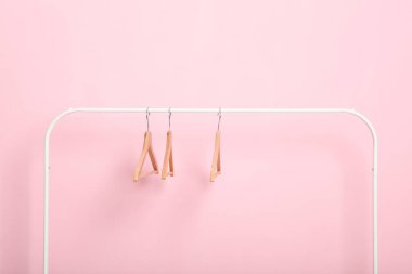 Boş giysiler renkli bir arkaplanda gardırop rafında asılı duruyor..