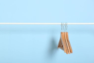 Boş giysiler renkli bir arkaplanda gardırop rafında asılı duruyor..