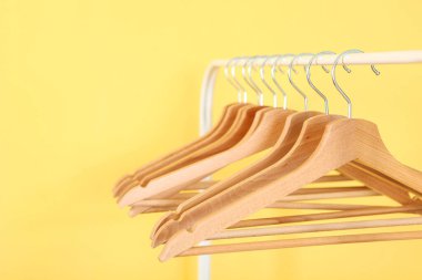 Boş giysiler renkli bir arkaplanda gardırop rafında asılı duruyor..