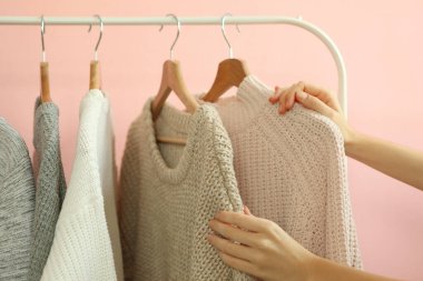 Kız elbise dolabından kalın bir kazak seçiyor..