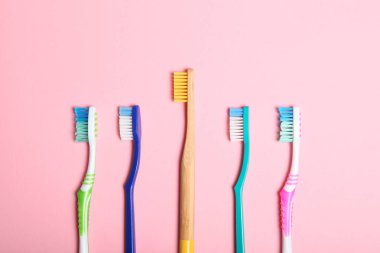 Renkli arka plan görünümlü doğal bambu diş fırçaları ve plastik..