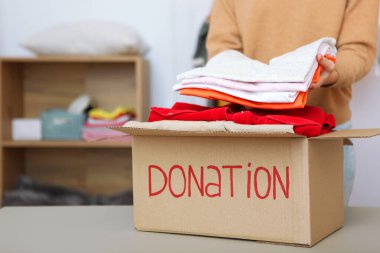 Kız bağış malzemelerinin olduğu bir kutuya koyar. Gönüllü olmak 