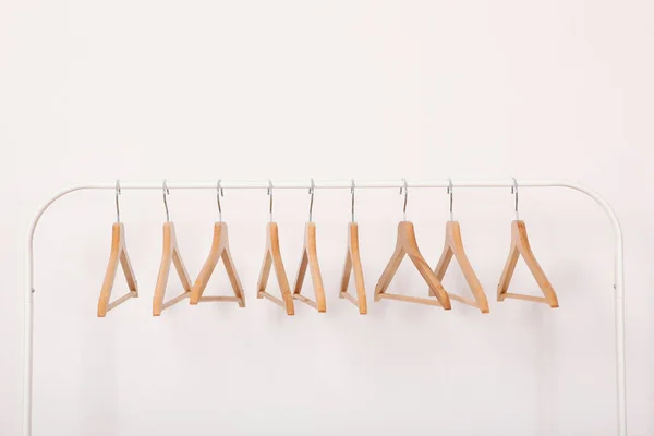 Άδεια Ρούχα Κρεμάστρες Μια Σχάρα Ντουλάπα Ένα Ελαφρύ Φόντο — Φωτογραφία Αρχείου