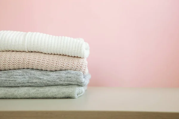 Una Pila Suéteres Calientes Sobre Mesa Sobre Fondo Color — Foto de Stock