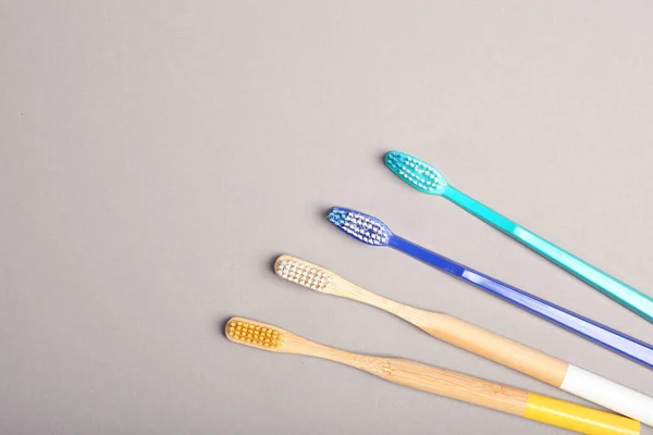 Naturliga Bambu Tandborstar Och Plast Färgad Bakgrund Ovanifrån — Stockfoto