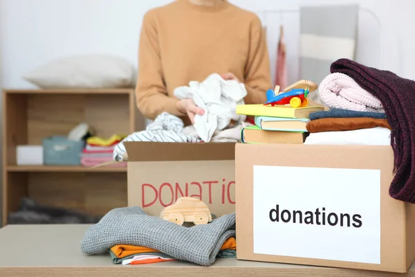 girl puts in a box with donations items. Volunteering
