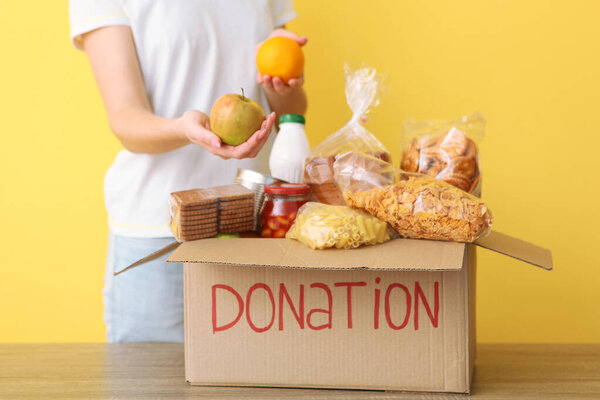 girl puts in a box with donations items. Volunteering 