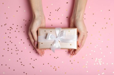 Renkli arka plan görünümlü kadın ellerinde hediye..