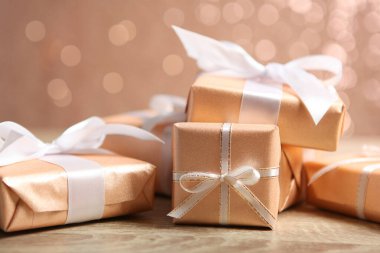 Parlak bir arka planda altın paketler halinde hediye kutuları. Tatil, hediye, Noel, doğum günü, yeni yıl, anneler günü..