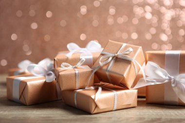 Parlak bir arka planda altın paketler halinde hediye kutuları. Tatil, hediye, Noel, doğum günü, yeni yıl, anneler günü..