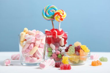 Masanın üzerinde renkli bir arkaplanda çeşitli şekerler ve tatlılar var..