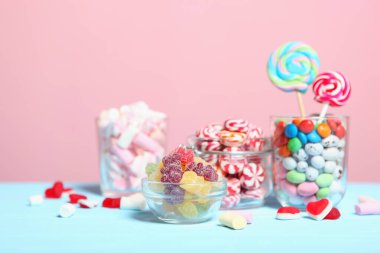 Masanın üzerinde renkli bir arkaplanda çeşitli şekerler ve tatlılar var..