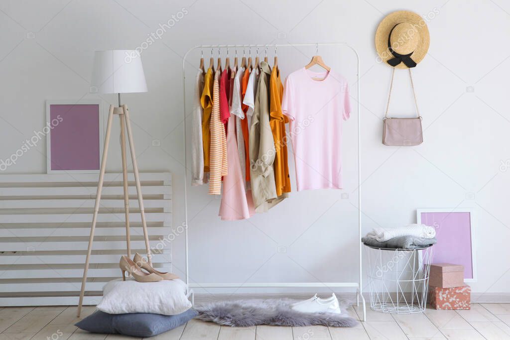 fashionable clothes on a rack in the interior of a bright room