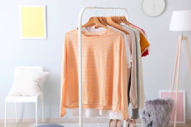 Soyunma odasının içinde bir askıda şık kıyafetler.