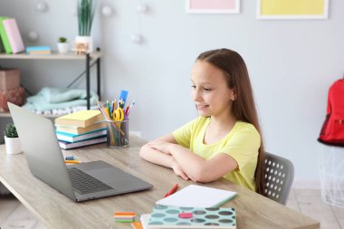 A child learns online at home through a modern laptop on the Internet.