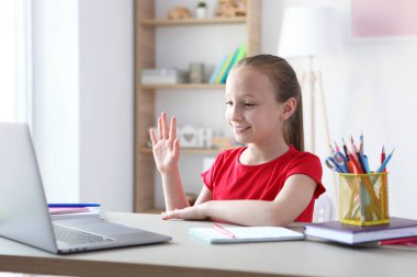 A child learns online at home through a modern laptop on the Internet.