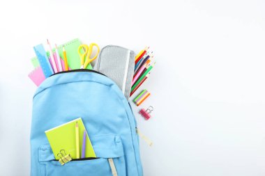 Okul çantası ve okul kırtasiyesi renkli bir arka plan görünümünde. Okula dönüş kavramı.
