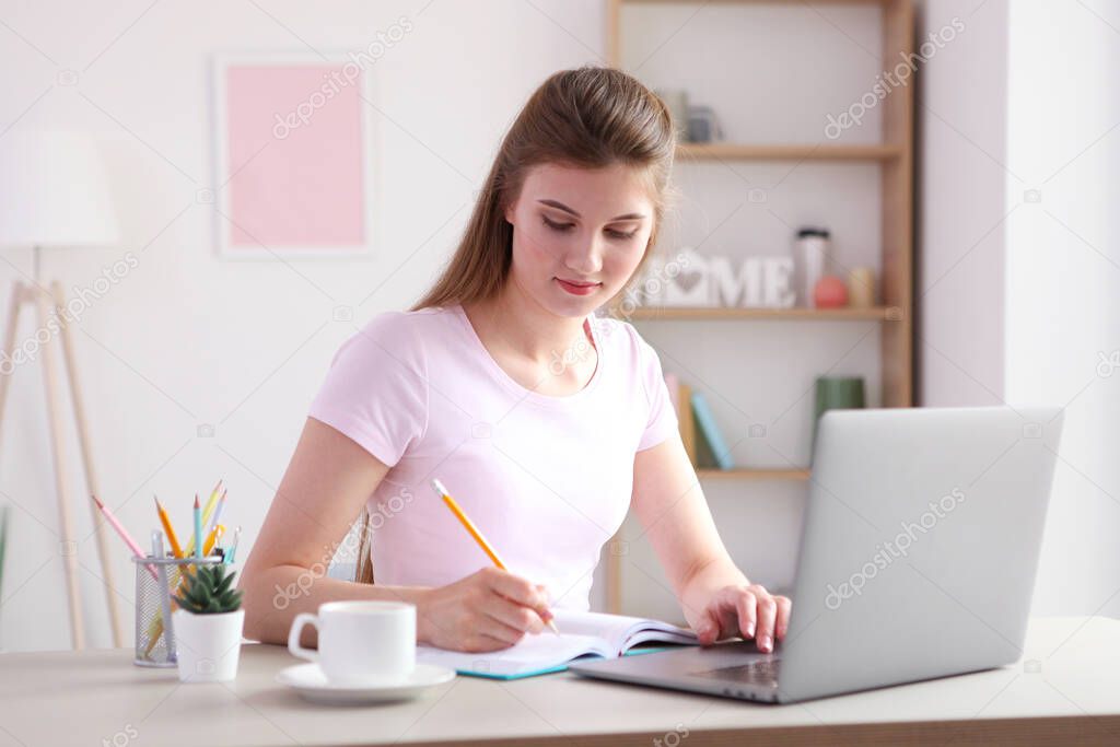 The girl works remotely from home using a modern laptop.