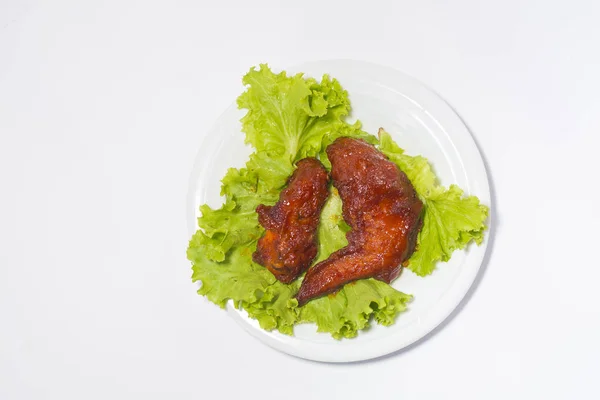 Bakade kycklingvingar med sesam och sallad med tallrik. Ovanifrån. — Stockfoto