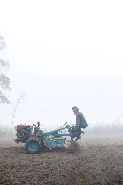 Bangladesh - 06 de janeiro de 2014: Em uma manhã nebulosa de inverno, um fazendeiro está lavrando suas terras com um trator de duas rodas em Ranisankail, Thakurgaon . — Fotografia de Stock