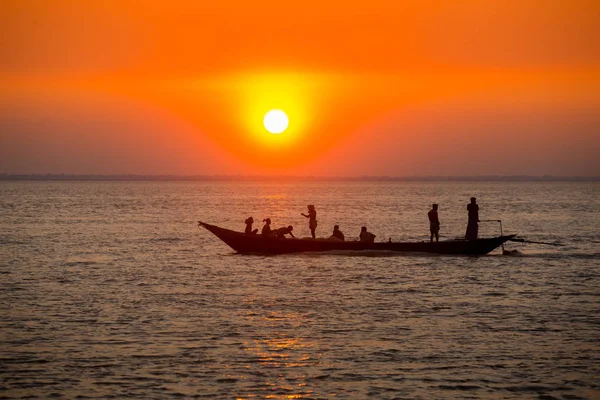 Coucher de soleil doré coloré sur la mer. Les pêcheurs rentrent chez eux avec des poissons, manuellement au coucher du soleil sur la plage de Char Samarj à Chandpur, Bangladesh . — Photo