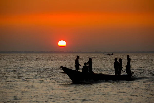 Coucher de soleil doré coloré sur la mer. Les pêcheurs rentrent chez eux avec des poissons, manuellement au coucher du soleil sur la plage de Char Samarj à Chandpur, Bangladesh . — Photo