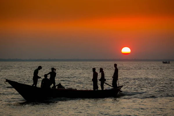 Barevný zlatý západ slunce na moři. Rybáři se vracejí domů s rybami, ručně při západu slunce na pláži Char Samarj v Chandpuru v Bangladéši. — Stock fotografie