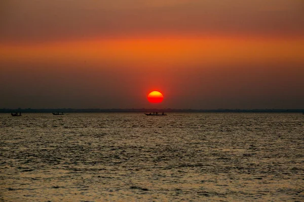 Coucher de soleil doré coloré sur la mer. Les pêcheurs rentrent chez eux avec des poissons, manuellement au coucher du soleil sur la plage de Char Samarj à Chandpur, Bangladesh . — Photo