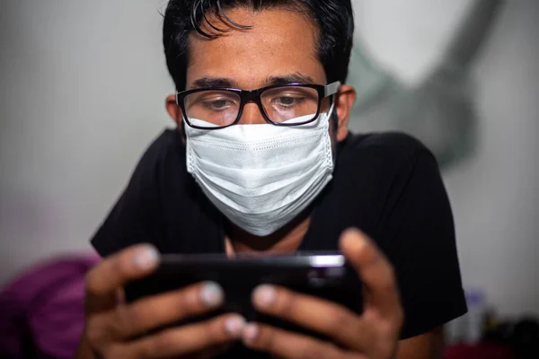 Portrait of a young man playing Mobile video games at Night deu to coronavirus epidemic.