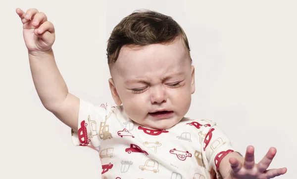 Lindo niño llorando levantando las manos. Pequeño niño con dolor, sufrimiento, dentición, rechazo y llanto . — Foto de Stock